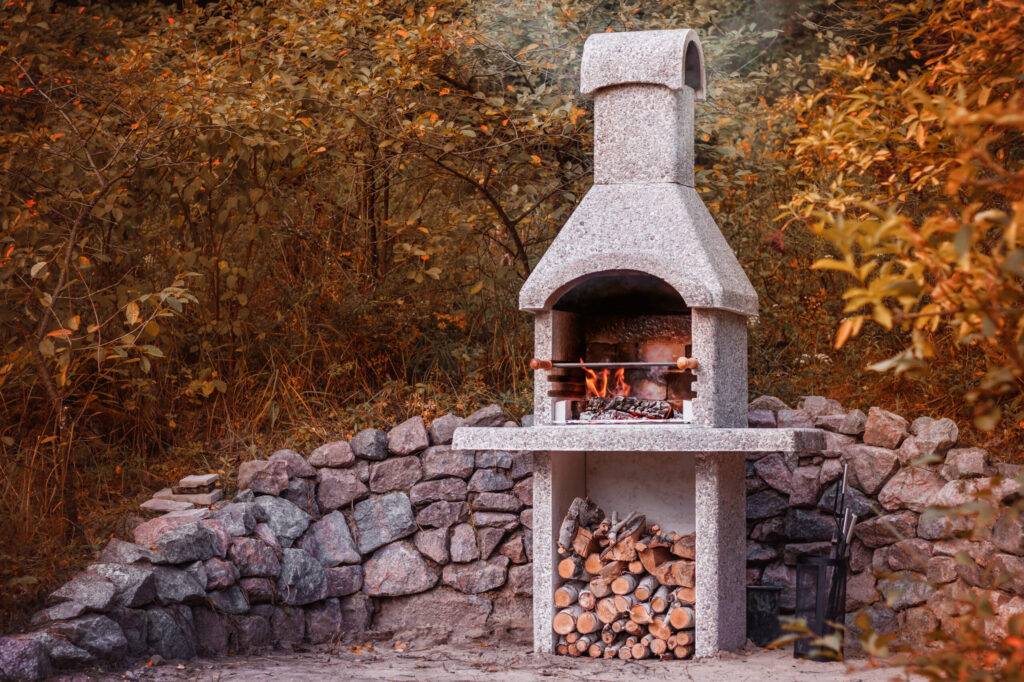 Stone garden oven for grill or barbeque is in a backyard at autumn season Stone garden oven for grill or barbeque is in a backyard at autumn season