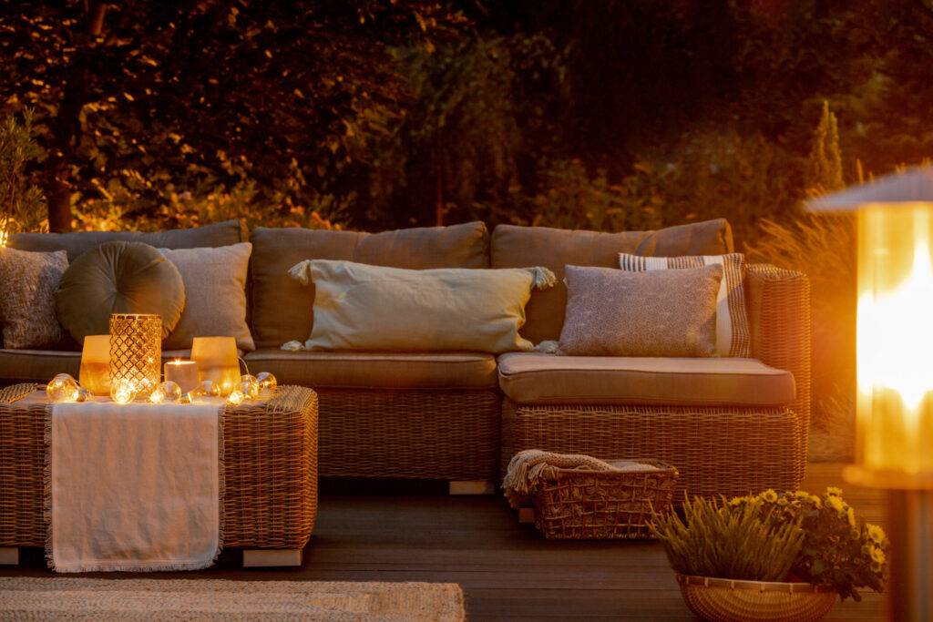 Autumn evening Wooden porch and rattan furniture with cozy outdoor furniture cushions on autumn warm evening