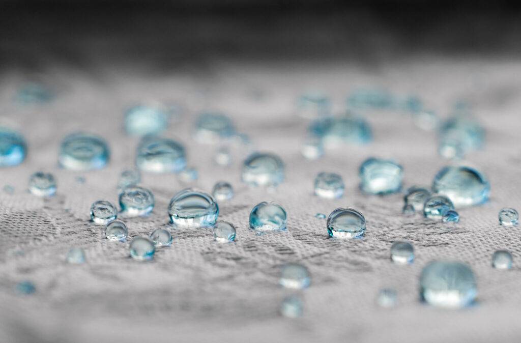 Blue drops on water resistance surface of textile fabric fibers. Macro a Waterproof Sealant